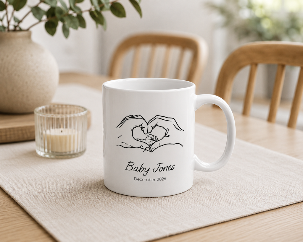 Personalized heart hands baby announcement mug displayed on a desk